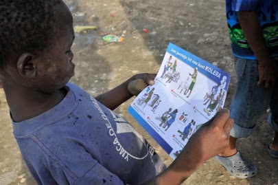 Um menino de Cité Soleil lê material educativo sobre a prevenção da cólera. Foto: OPAS/OMS.